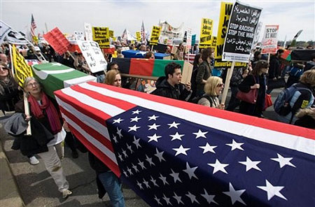 Anti-war protesters carry mock coffins draped in American flags across the Memorial Bridge to Arlington, Va. , during a march to the Pentagon, marking the sixth anniversary of the war on Iraq, Saturday, March 21, 2009.